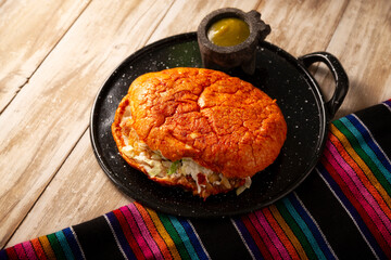 Pambazo. Mexican sandwich marinated in red sauce and roasted on a comal traditionally stuffed with potatoes and chorizo, a classic of Mexico City street food.