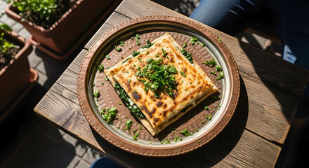 A delicious Turkish gozleme filled with spinach and cheese on a rustic wooden table