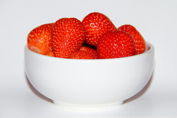 MANY STRAWBERRIES IN A WHITE BOWL ISOLATED