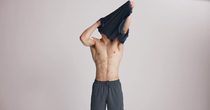 Bodybuilder, face or man with tshirt in studio, fitness or training progress for muscle development. Confident, transformation or athlete remove clothes, space or workout results on white background