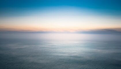 Obraz premium Misty Morning Ocean with Sunlight Streaming Through Fog 