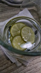Fresh lime slices soaked in clear water in a glass cup, for health, symbolizing detoxification, freshness, and natural health benefits.