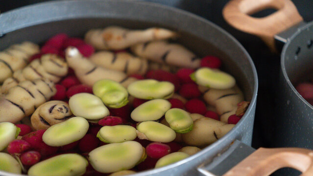 Cooking pot with green broad beans and cubios boiling in water / Olla con habas verdes y cubios cocin&aacute;ndose en agua