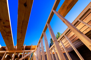 Workers are framing structure with wooden beams in construction site