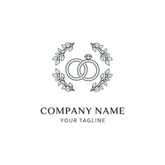 Elegant wedding rings logo with diamond and botanical wreath frame.