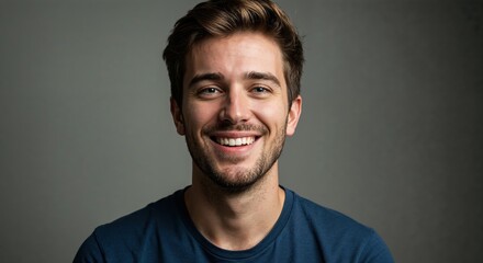 Obraz premium Radiant Expression: A young man with captivating eyes beams with genuine joy, his warm smile radiating positivity against a soft, muted backdrop. 
