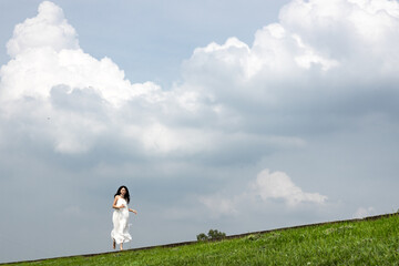 Obraz premium White clad beauty leisurely strolls under white clouds