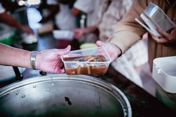 The hands of the hungry are asking for food from the donor