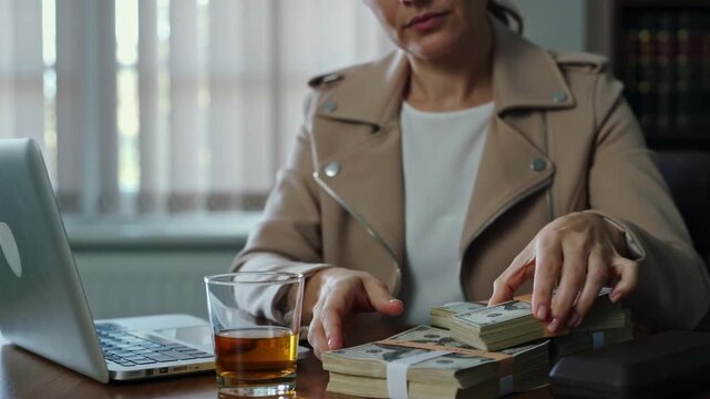 The person in the spotlight is rereading a stack of money.