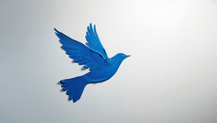 Stylized royal blue dove sculpture soaring on a plain white background