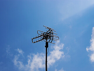 View of an antenna with blue sky in the background. 