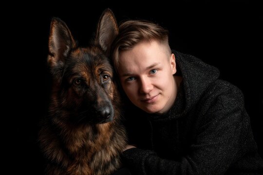 Studio image of a young man with his labrador dog