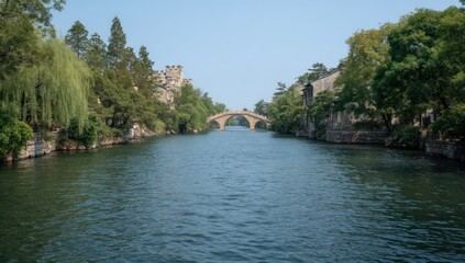 Fototapeta premium Tranquil Canal Scene with Bridge and Historical Architecture in Suzhou China