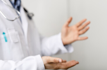 Doctor in white coat presenting or explaining something with hands open, medical professional....