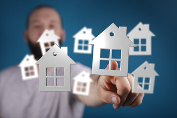 Hand pointing at house symbols, representing the concept of choosing, buying, or owning a home. Ideal for real estate, housing, and property-rel