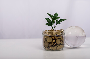 Conceptual image of financial growth, investment, and global economy. Featuring a jar of coins with...