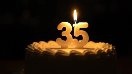 A video showcasing a birthday cake with "35" candles burning brightly, illuminating a dark setting in a heartfelt celebration. - Powered by Adobe