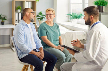 Fototapeta premium Doctor meets senior couple in a clinic to review results, medical history and plan treatment during a private consultation for wellbeing. Clear communication reassures the patient and family.
