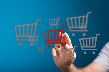 Concept of online shopping with hand touching shopping cart icons. E-commerce concept, online...