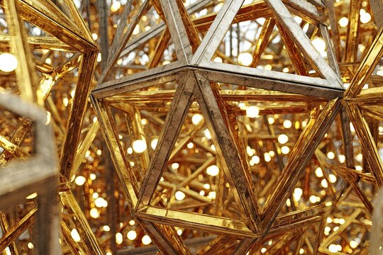Complex golden geometrical structure with light bulbs inside