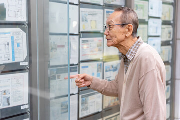 不動産広告を見るシニア男性