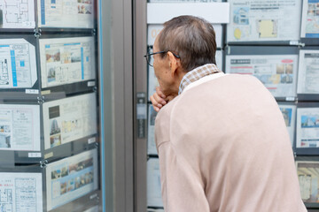 不動産広告を見るシニア男性