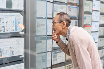 不動産広告を見るシニア男性