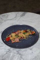 A delicious plate of spaghetti with fresh vegetables, and meat, ready to be enjoyed