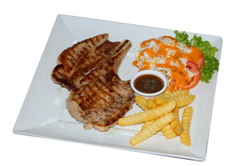 Delicious grilled pork chop with a variety of sides on a plate. The dish includes french fries, salad, and a sauce. This culinary delight is ready to be enjoyed.
