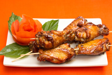 Grilled skewers with cucumber garnish and artistic food presentation