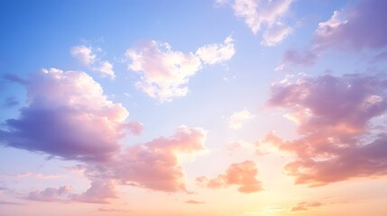 Obraz premium Soft pink and blue hues blend in the sky as the sun sets, creating a serene view of fluffy clouds in a peaceful evening atmosphere