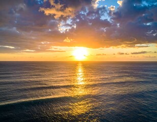 Obraz premium Golden sunset paints the ocean and clouds. Light refracts across water