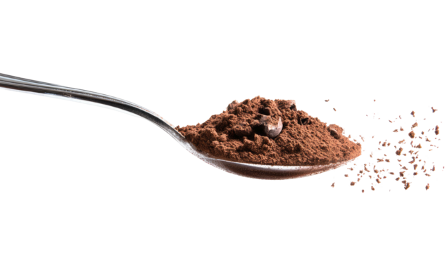 A silver spoon displays a mound of brown powder, with some particles scattered nearby