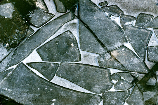 Bruckst&uuml;cke von erneut einfrierenden Eisschollen, die auf dem Wasser treiben