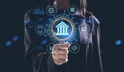 Futuristic banking concept with hologram interface icons and financial technology graphics on dark background held by businesswoman.