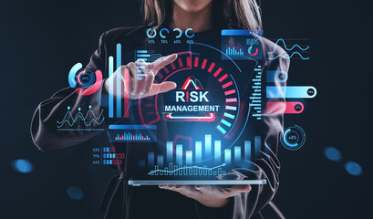 Businesswoman interacting with futuristic hologram interface showing risk management concept and analytics on dark blue background..