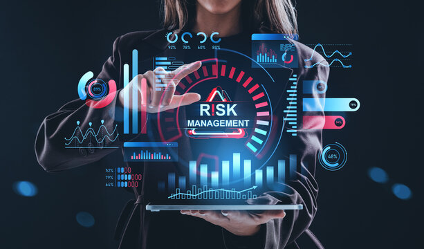 Businesswoman interacting with futuristic hologram interface showing risk management concept and analytics on dark blue background..
