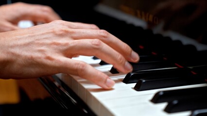 Obraz premium Hands Playing Piano Keys Close-up with Motion Blur for Music Learning and Education Content