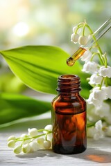 Lily of the valley essential oil: drop from pipette over amber bottle, SPA and aromatherapy