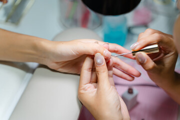 Close-Up of a Manicure Process with Professional Nail Care, Hands Being Pampered at Beauty Salon with Focus on Precision and Attention to Detail