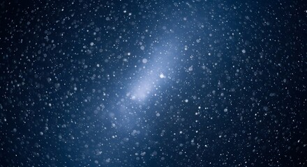 Abstract blue background with glowing light and falling bokeh snow particles, creating a magical