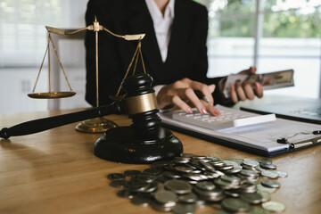 Judge’s gavel placed on dollar bills and coins with a businessperson signing legal documents, symbolizing law, money, and justice.