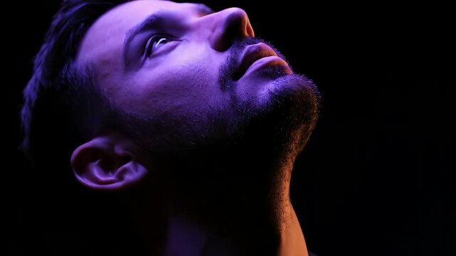 Looking Upward Young Man Face in Dark Studio Dramatic Lighting