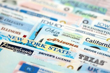 Big amount of driving licenses from different USA states. Stack of driving license specimen cards