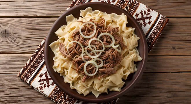 Delicious traditional kazakh dish beshbarmak served on a plate with onion rings and on a table