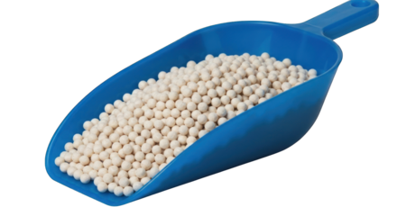 Scoop full of white spheres against a dark background
