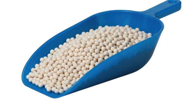 Scoop full of white spheres against a dark background