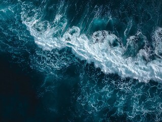 Fototapeta premium Aerial View of Turbulent Ocean Waves with Foamy White Crests Against Deep Blue Water