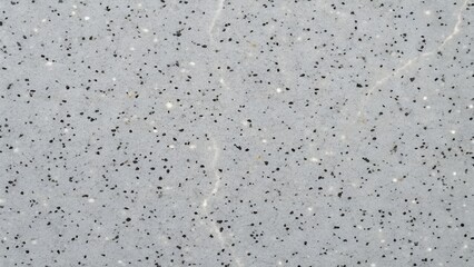 Close up horizontal shot of light gray speckled texture with subtle shadows and variations