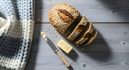Freshly Baked Bread and Butter on a Wooden Table with a Cozy Knitted Blanket